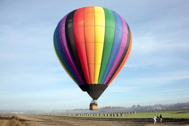 Dave Williams of Enchanted Balloon Tours flies in low over the misty morning Black Dirt fields of Warwick lined with onion crates on Saturday morning. Balloon rides have been launching out of Sunflower Valley Farm in Wawayanda on the weekends.