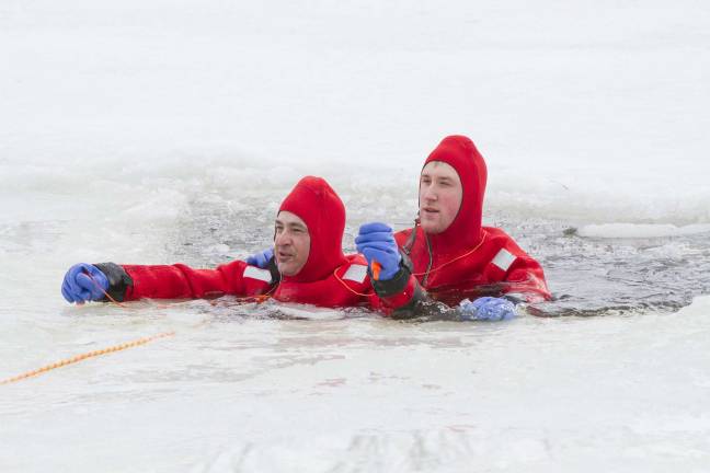 Preparing for when hell freezes over Pine Island firemen Scott Hansen (left) and Matthew Sampson (right) get ready to be pulled to shore by fireman with rescue ropes during a drill at the Pine Island Turf Nursery on Sunday morning February 23, 2014.