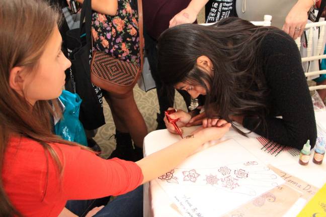 More than 500 attend Girls World Expo Neha Desai of Mountain Side, N.J. applies a henna tattoo on Bridget McGill of Warwick.