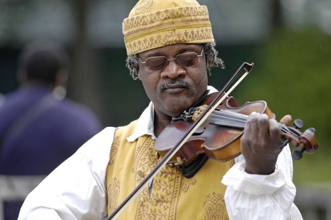 Philipsburg Manor welcomes visitors to 'Discover Pinkster' Fiddler Henrique Prince.