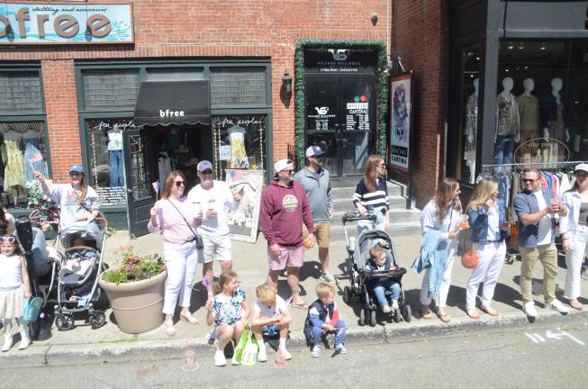 Departed veterans honored Families with their children watch the parade go by.