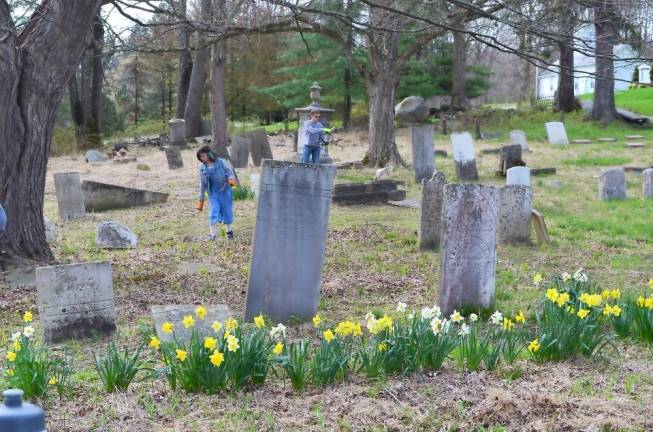 Warwick residents pick up fallen tree branches at the Amity Cemetery in a community effort to clean up the cemetery, spearheaded by the Warwick Historical Society’s Cemetery Preservation Clean-Up Crew.