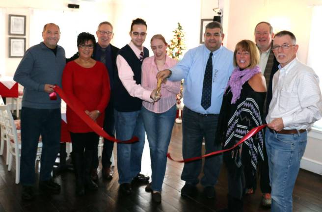 Photo by Roger Gavan On Monday, Dec. 12, Town of Warwick Supervisor Michael Sweeton (right), along with members of the Greenwood Lake and Warwick Chambers of Commerce, joined co-owners Sel Gunver and his wife Tina and their son Alex (center) to celebrate the new location of Rooster Cafe Bistro at 92 Windermere Ave. in the Village of Greenwood Lake.