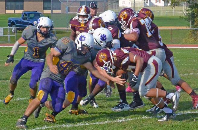 Wildcats take down the Kingston Tigers Photo provided by Greg Sirico/Warwick Valley High School Seniors Michael Houlihan, Justin Giannino and AJ Sakac stop KingstonþÄôs quarterback in the Wildcats' homecoming victorylast Saturday.
