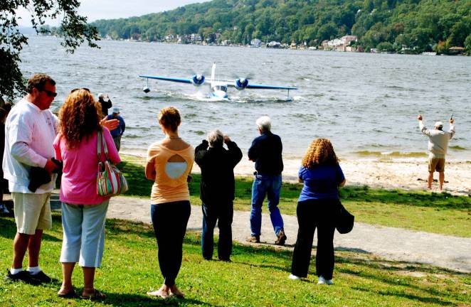 Ten seaplanes splash down onto Greenwood Lake Photo by Ed Bailey Jim Moore, pictured here on the far right, waves in a 1943 Grumman Widgin seaplane for parking on Greenwood Lake last weekend during the sixth annual Seaplane Fly-in at the Thomas P. Morahan Waterfront Park. Moore was the chairman of the event.