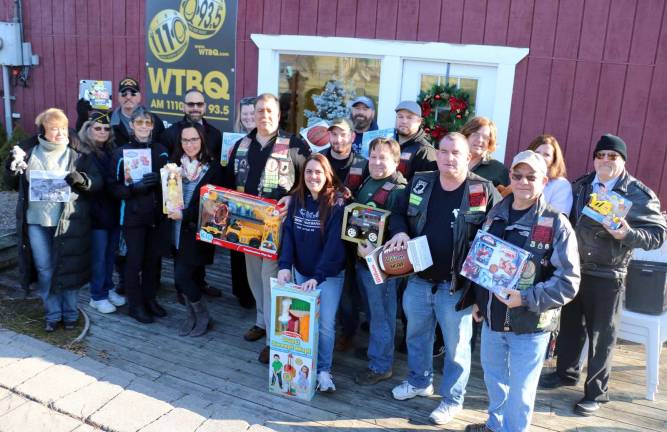 WTBQ Toys for Military Tots distribution day Photo by Roger GavanOn Monday, Dec. 9, contributors to the third annual Toys for Military Tots toy drive assembled at the office of Orange County Community Radio WTBQ (1110 AM/93.5 FM) to celebrate the success of the program and the distribution of the toys. Front from left, Taylor Sterling, holding up a photo of county Executive Steve Neuhaus, who is training for deployment to the Middle East, Laura Smykla and Laura Rollins, Disabled American Veterans, Cindy Leandro, Warwick Valley Central School District, Bob Caridi, president of f NAM KNIGHTS, Lindsay Kenneally, Hudson Valley Seafood, and Aaron Ubides, Pat Rooney and Shane Laden of Nam Knights. Left from rear, Pete Rose, head of Disabled American Veterans Volunteers, Dr. David Leach, superintendent of Warwick Valley School District, Meghan McGourty, of Warwick Valley School District, Charlie, Hudson Valley Seafood, Tim Finnegan of Nam Knights, Frank Truatt, owner of WTBQ, Anthony Iacono of Nam Knights, Susan Dean of McKesson Corp. and Dave Swart of Nam Knights.