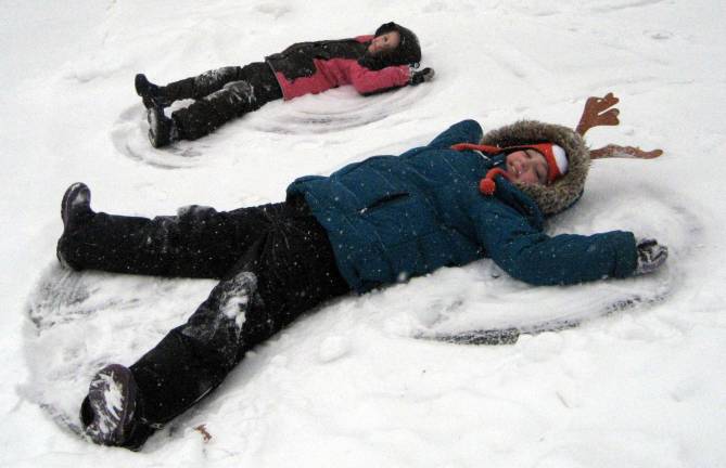 Kids loved the early snow Sisters Sophia, 8, and Olivia, 12, Parkin enjoy making "Snow Angels."