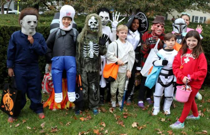 Ghosts, goblins, witches and what-have-you assemble for the parade outside Lewis Park on Church Street.