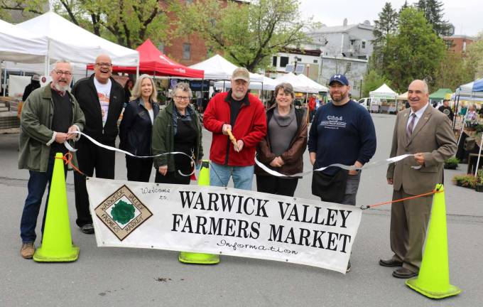 Warwick Farmers Market officially opened Sunday, May 13 Photo by Roger GavanThe Warwick Farmers Market opened Sunday, May 13, celebrating its 25th anniversary. Pictured from left to right are: Warwick Mayor Michael Newhard, Warwick Valley Chamber of Commerce Board members Wayne Paterson and Kim Starks, Market Manager Penny Steyer, Market Chair Jack Hillery (cutting ribbon), farmers market vendors and representatives Amanda Steng and Chuck Cambareri and Town of Warwick Deputy Supervisor James Gerstner.