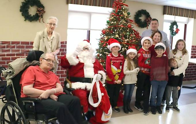Schervier Pavilion resident Thomas Shermas joins members of his large family for a photo with Santa.