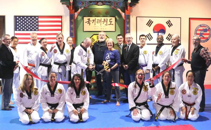 Chosun Taekwondo Academy and Hath Yoga Center celebrates 20 years Photo by Roger GavanOn Tuesday, Nov. 28, Town of Warwick Supervisor Michael Sweeton (far left), Mayor Michael Newhard (far right) and members of the Warwick Valley Chamber of Commerce joined Grandmaster Doug Cook and his wife, Patty (center), along with instructors and students to celebrate the occasion with a ribbon-cutting ceremony.