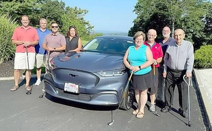 Pictured from left to right: Members of the Golf Classic Committee and Hole-in-One Sponsor include Garrett Durland (Co-Chair), Leo R. Kaytes, Michael McSweeney, Marguerite Meier, Katie Bisaro, Douglas Stage, Frank Petrucci (Co-Chair) and Leo Kaytes. They are pictured with the Hole in One Contest prize, a 2021 Ford Mustang Mach-E donated by Leo Kaytes Ford. Provided photo.