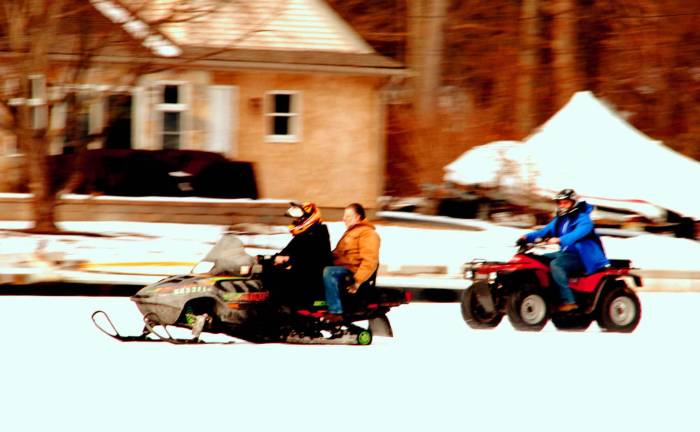 On frozen Greenwood Lake ATVs and snow sleds speed along the forzen lake.