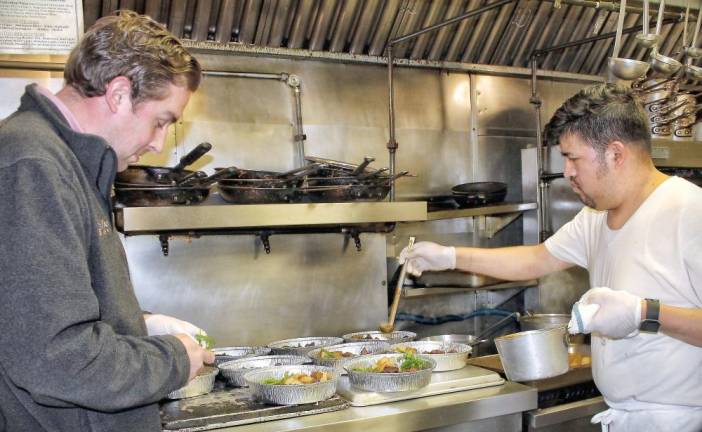 The Crystal Inn's Ryan Zygmunt watches as his chef prepares the meals.