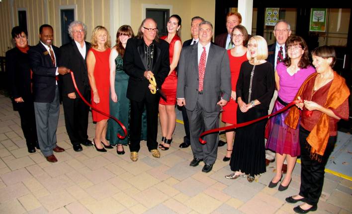 Arts Center hosts grand opening Photo by Roger Gavan On Oct. 11, members of the Warwick Valley Chamber of Commerce and others joined the Kings Theater Board of Trustees for the grand opening of the Sugar Loaf Performing Arts Center (SLPAC). Interim Director Paul Ellis, cutting the ribbon, and SLPAC President Bill Sunkel (center) are surrounded by members of the Kings Theater Board of Trustees and the chamber's Board of Trustees.