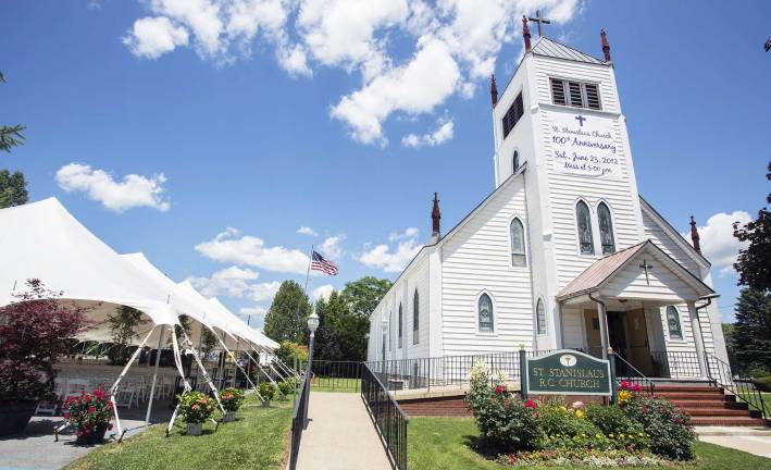 The flag rises over Pine Island A huge tent covers the parking lot of St. Stanislaus Church in Pine Island and a large American Flag waves in the background as the church gets its 100th Anniversery celebration under way at 5PM this afternoon.