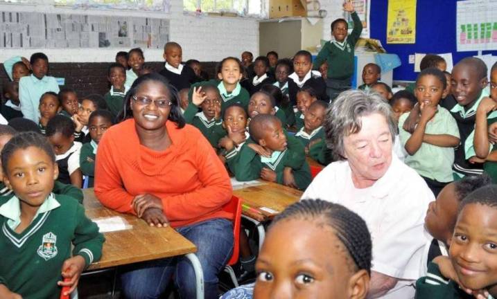 ‘Coins for Change’ Tuxedo Park resident Sue Heywood, right, visits a second- and third-grade in Mablomong, South Africa. When she asked if she could read a story to them, she was told: "We donít have any books."