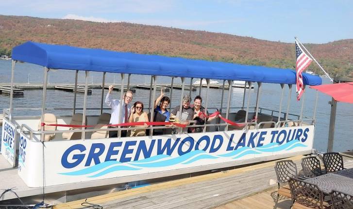 Michael Johndrow, executive director of the Warwick Valley Chamber of Commerce joined Cove Castle Manager Andrea Muster (left), operating partners Bob Pereira and Sandra Frank (right) along with Elena Dykstra (center), owner of Greenwood Lake Marina, for a ribbon cutting ceremony to celebrate the official launch of Greenwood Lake Tours.