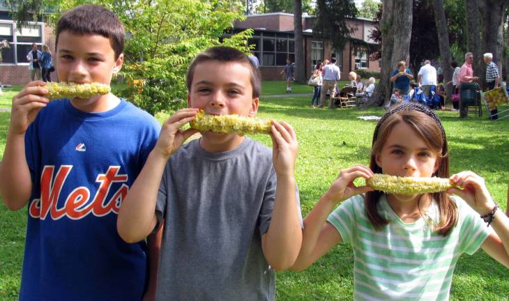 St. Stephen’s parish picnic held Sept. 8 Most everyone, especially kids, loves corn on the cob. From left, Paul Eugenio, 11, his brother Matthew, 9, and sister Mary, 8.