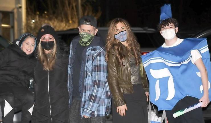 Driedel Mascot Adam Stanton of Warwick poses for a photo with Chana Burston and the Weiss family of Monroe at Chabad’s Hanukkah Drive-in Experience.