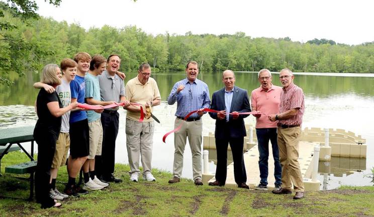 Town of Warwick Supervisor Michael Sweeton (far right} and Warwick Valley Chamber of Commerce Executive Director Michael Johndrow (second from right) joined Joe Rampe (center cutting ribbon), his family, friends and associates for the unveiling of the sign and a ribbon-cutting ceremony at the launch site. Photos by Roger Gavan.