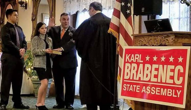 Provided photo Pictured from left to right are Karl A. Brahenec's children - Karl W. Brabenec and Kimberlee Brabenec, who holds the bible as the assemblyman is sworn in by Orange County Court Judge Robert Freehill.