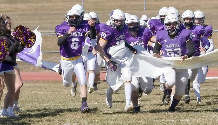 Justin Orlando (6), Joey McLaughlin (10) and Brian Laroe (63) lead the Wildcats onto the field on Saturday March 13, against Kington. Photos by Tom Bushey.