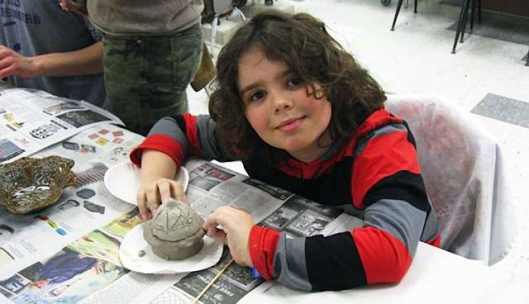 Empty Bowls project raises $35,000 A young potter enjoys creating a project with clay.