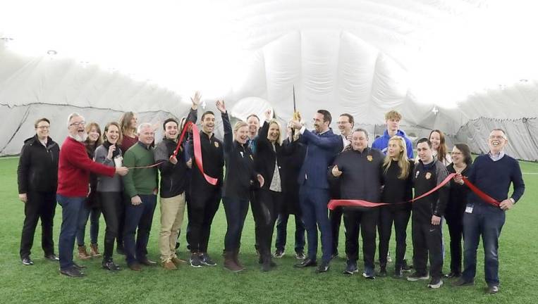 On Thursday evening, Feb. 6, Town of Warwick Supervisor Michael Sweeton (right), Mayor Michael Newhard (front left) and members of the Warwick Valley Chamber of Commerce joined owners Christian and Raluca Fuchs (center), their staff and management to celebrate the official grand opening of the Hudson Sports Dome.