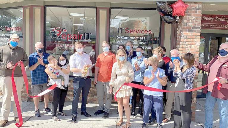 On Thursday, Oct. 1, Florida Mayor Daniel Harter (far left), Deputy Mayor Thomas Fuller (second from left) and members of the Warwick Valley Chamber of Commerce joined owner Ryan O’Leary (cutting ribbon), business associates, families and friends to celebrate the grand opening of RepairIT with a ribbon-cutting ceremony. Photo provided by Bea Arner.