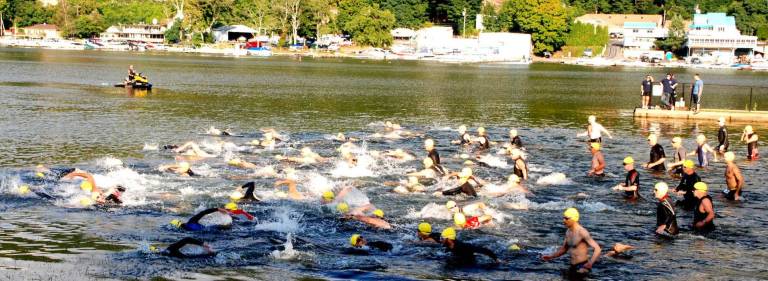 GWL Swim, bike, run Competitors splash into Greenwood Lake at the start of the triathlon.