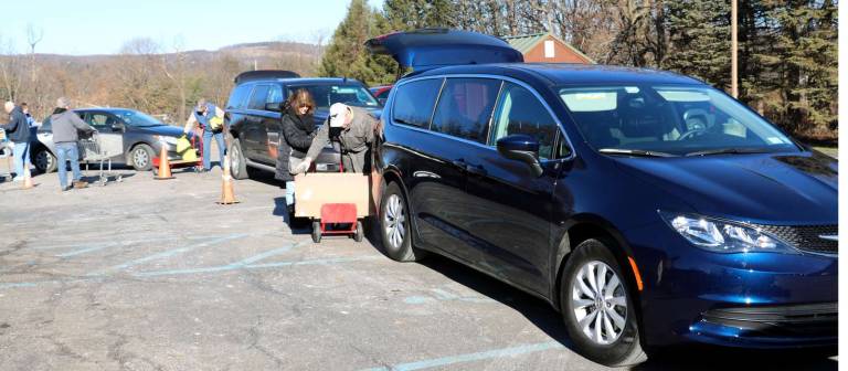 Warwick Ecumenical Food Pantry distributes more than 200 Christmas food baskets Santa's helpers stand by as donors drop off their Christmas baskets.