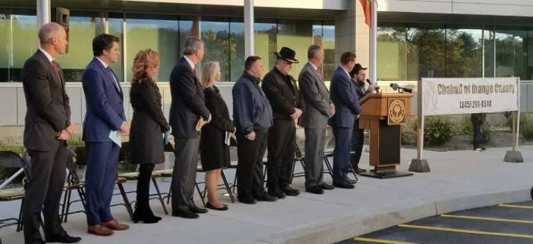 'How do we respond to baseless hatred? Wanton love' Elected officials look on as Rabbi Meir Borenstein speaks at the government center (Photo provided)