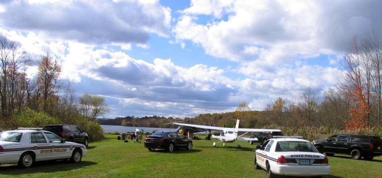 Who was that man in the black SUV? Black SUVs, filled with agents in bulletproof vests, along with Connecticut State Police cars raced down the grass runway towards a parked Cessna 206 six place aircraft and a helicopter.