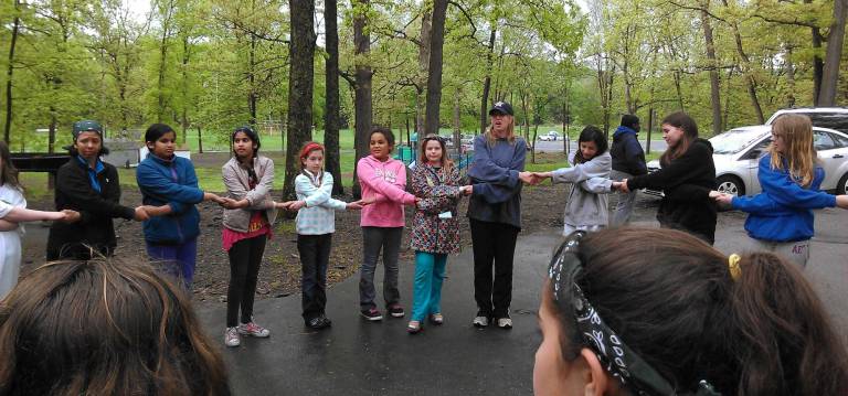 ‘A rewarding experience’ Girls and leaders from Monroe Girl Scout Troop #233 ended the Camporee at Chester Commons Park with a friendship circle where they shared what they learned and liked about this yearís event.