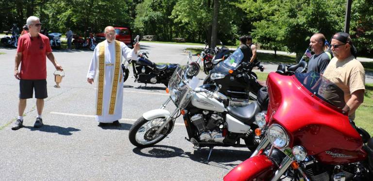 St. Stephen's seventh annual motorcycle blessing and ride draws more than 70 participants Photos by Roger Gavan St. Stephen’s pastor, the Rev. Jack Arlotta, assisted Knights of Columbus member John Mac Donald, blessed each of the bikes individually.