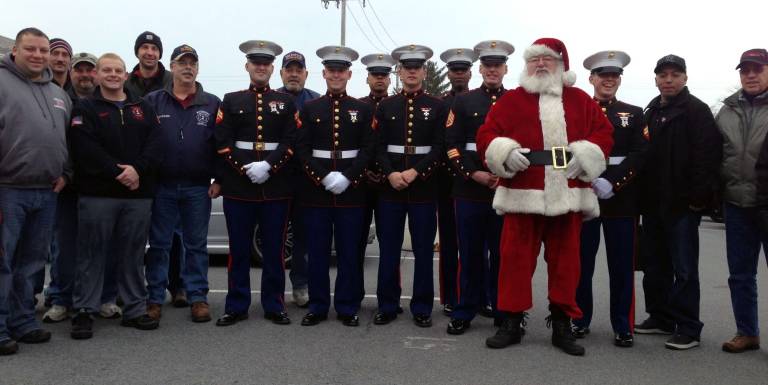 Toys for Tots Train arrives in Warwick Marines and Santa pose with Warwick volunteers.