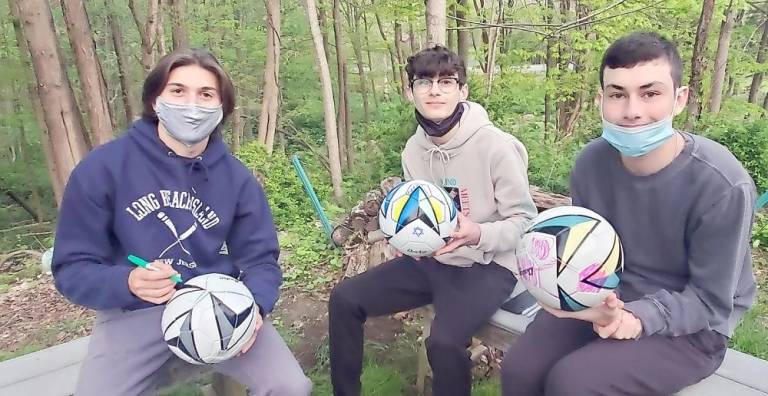 Joey Melillo of Monroe, Omer Mosker of Monroe and Ryan Leeds of Chester decorate summer-themed soccer balls to be gifted to local children with special needs at Chabad’s CTeen program.