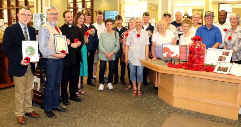 From our hearts to yours Photo by Roger Gavan On Thursday, May 3. Town of Warwick Supervisor Michael Sweeton (far right), Mayor Michael Newhard (left), members of Knitting Our Warwicks Together, VFW Post 4662, the Warwick Sesquicentennial Committee and many other contributors assembled at the Albert Wisner Public Library as the Rev. Richard Marrano, parochial vicar of the RC Church of St. Stephen, the First Martyr, blessed 664 hand-crafted poppies, now shipped to England.
