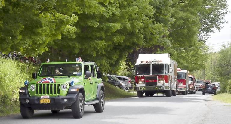 The Pine Island Fire Department drove through the hamlet’s streets on Memorial Day as residents came out to watch and honor the military veterans. Photo by Robert G. Breese.