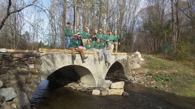 Rotten, broken, dangerous Goosepond bridge is repaired The volunteer crew from the New York New Jersey Trail Conference enjoys the view from the newly rebuilt bridge over the Seely Brook (Photo by Frances Ruth Harris)