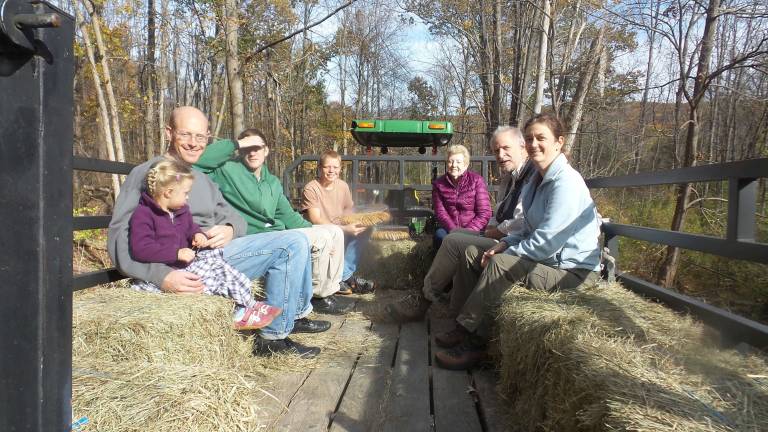Rotten, broken, dangerous Goosepond bridge is repaired Ann Wright with her dad, Arno Wright, Colin Wegner, Wilfred Wright, Nancy Board, Bob Calipel and Linda Mookin. The Bruderhoft Community, provided the tractor ride from Spruce Hill Court off of Larou Road in Chester to the new Seely Brook bridge, which now connects Laroe Road and Route 17M in Goosepond Mountain Statet Park. (Photo by Frances Ruth Harris)