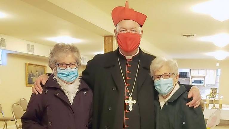 Cardinal Dolan poses with St. Stanislaus parishioners Theresa Paddock (L) and Helen Feagles, who brought their Easter Baskets.