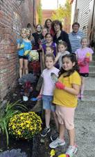 Mission accomplished: Brownies Olivia Bird, Brynn Hasbrouck, Molly Brady, Ava Hagen, Lila Monti, Grace Brown, Megan Roe, Mia Haysom, Taylor Gillen and Jayden Connolly and Warwick Valley Gardeners Mary Berrigan, Irena Ihanchak and Laurie Unick on the Carriage Path in the Village of Warwick. Not pictured are troop leaders Kim Brady, Jen Gillen and Andrea Roe. Provided photo.