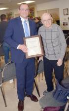 Mayor Jesse Dwyer presents a plaque to Jack Rader, who was honored as the 2020 Greenwood Lake Citizen of the Year during the Village Board’s meeting late last month. Rader received a standing ovation from the audience, which included three generations and 13 members of his family as well as members of the GWL Ambulance Corps and Fire Department. His son, Warwick Police Lt. John Rader, expressed how grateful he was for the Village Board’s decision. “As a family member, I want to thank you for the honor you have bestowed upon my father.” Jack Rader himself added: “It is an honor to be citizen of the year. I was very taken aback and I am so appreciative and grateful to have been chosen.” Once the meeting adjourned, many people retired to the Ambulance Corps building for cake.