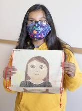Sixth grader Kenya Vicente holds up an unmasked self portrait she did as part of a class project at Warwick Valley Middle School on Sept. 21. Photos provided by the Warwick Valley School District.