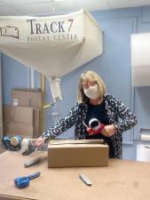 Track 7 Postal Center owner Eileen Patterson suspected something was amiss regarding a nervous customer who came to her store to ship a package. She called the Warwick Police Department, who discovered the customer was being scammed. Photo by Linda Smith Hancharick.