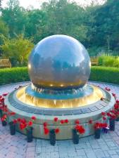 The September 11 Memorial at the Orange County Arboretum at Thomas Bull Memorial Park features a black 10-ton rotating granite globe that hydroplanes in a pool of water surrounded by the names of the 44 local victims identified on bronze plaques along the perimeter of the pool.