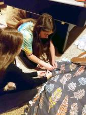 CTeen members Samantha Hamel of Monroe and Yershalem Pinkus of Warwick work together making a fleece blanket for the needy at Chabad of Orange County’s CTeen Giving event