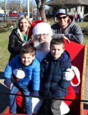 Jessica and Joe Altieri and their sons Vinny, 3, and Joey, 5, pose with Santa during his annual early visit to Warwick. Photo by Roger Gavan.